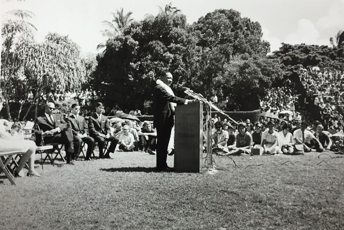 Black and white image of Martin Luther King Jr. speaking at a podium at Andrews Amphitheater