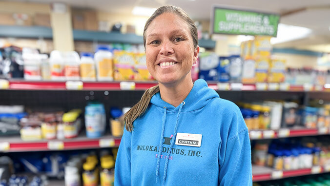 woman wearing blue hoodie standing in a pharmacy