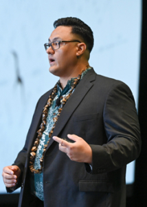person in a suit and aloha shirt on a stage