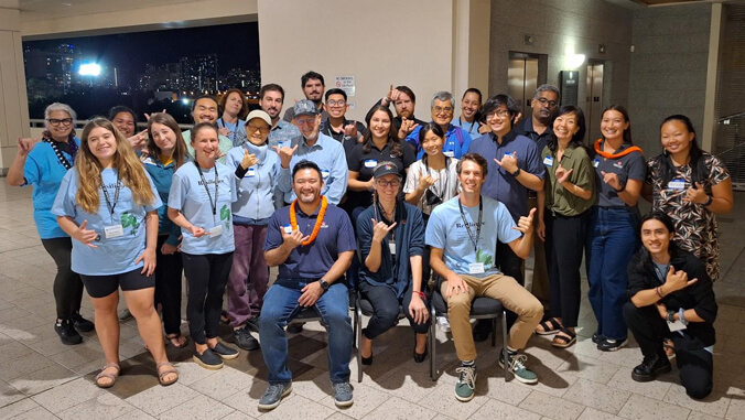 Group of people smiling and flashing shaka