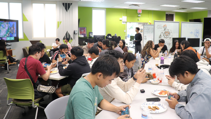 people sitting in a room playing a mobile video game