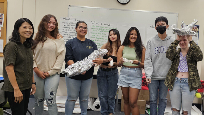 Students holding foil props in a classroom