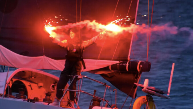 person waving flares on a boat