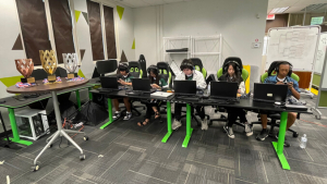 five people on desks playing video games