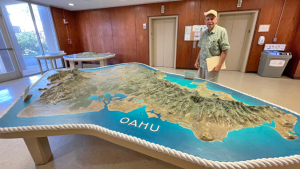 person standing in back of a large map of Oahu