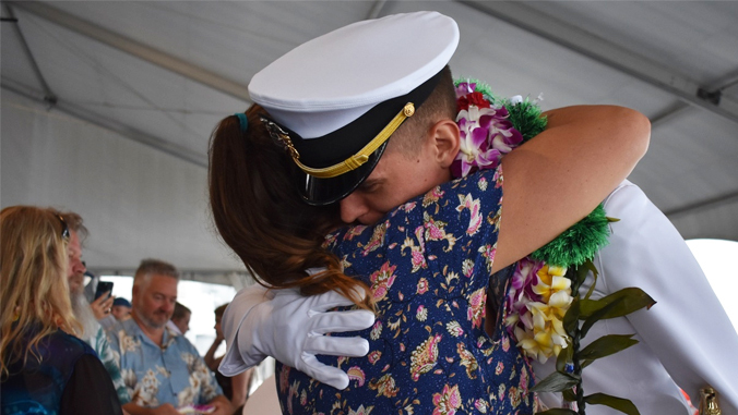 simmons gets a hug from a loved one at ceremony