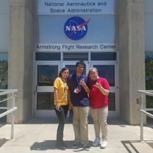 Students flashing shaka in front of NASA building
