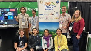 Eight people with a Change Hawaii sign and table