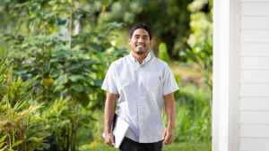 Jimenez smiling and holding a laptop