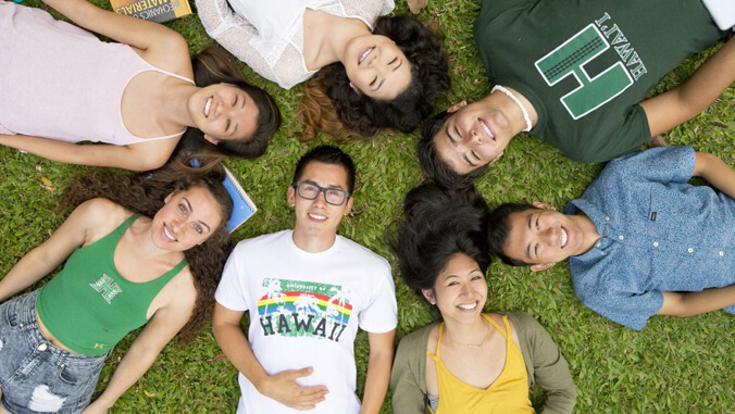 Students lying in a circle looking up