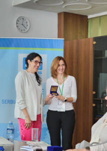 two people smiling with an award