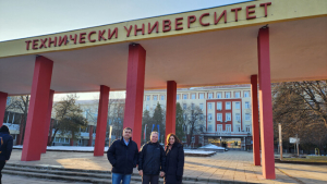 three people standing in front of a large sign