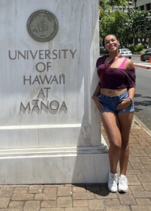 Jaelynn Farias next to uh manoa entrance sign