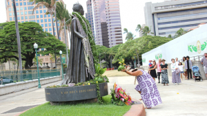 woman placing offering at Queen Liliuokalani's statue