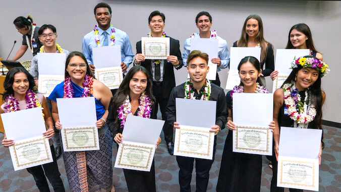 student holding certificates