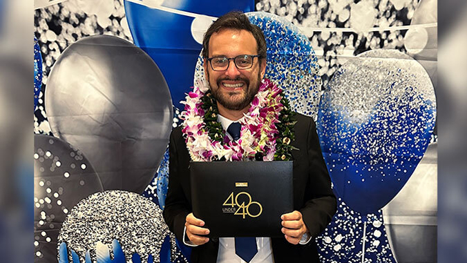 A person holding a lei and a certificate