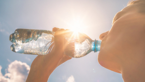 Woman drinking water under hot sun