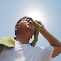 young man sweating under hot sun