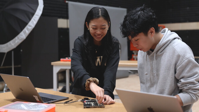 two students working with laptops.