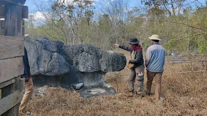 two people analyzing a large rock formation