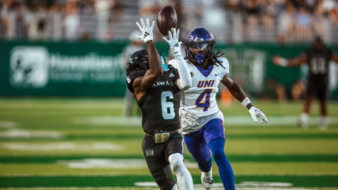 person in a uniform catching a football