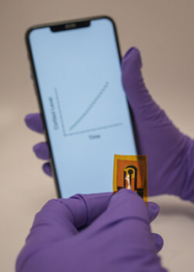 person holding a phone and a bendable sensor