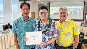 3 men, one holding award