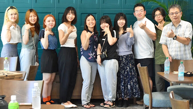 group of people waving shaka