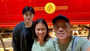 family in front of red sign