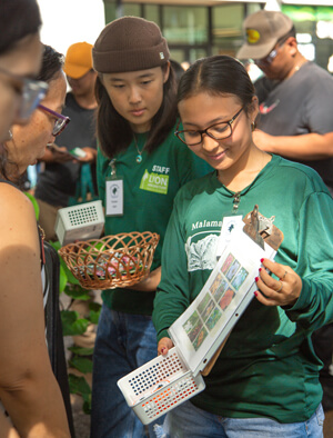 2 people showing photos to another person