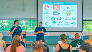 two people standing and talking to an audience