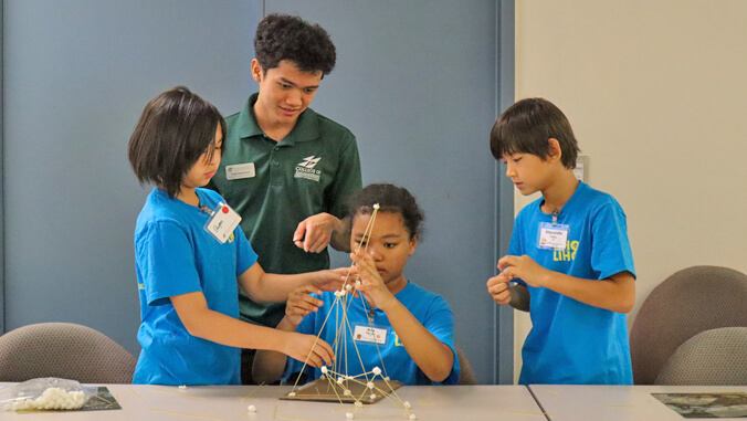 people building a spaghetti tower