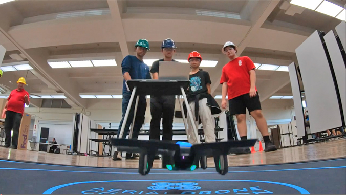 people in front of a computer next to a drone