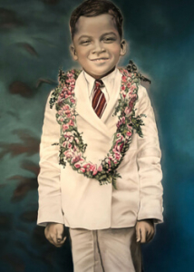 Boy in a suit wearing lei