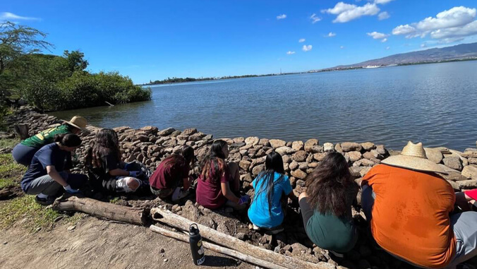 people sitting by fishpond