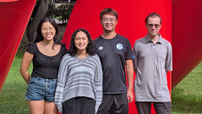 four people standing and smiling