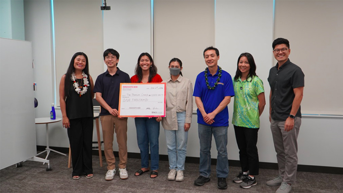 people standing holding a large check