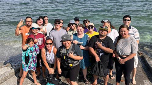 people smiling for a photo on the shoreline