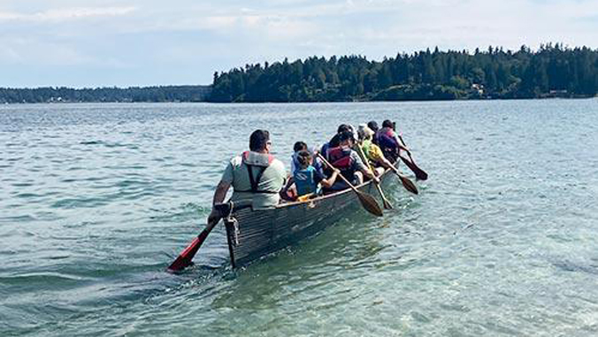 people paddling in a canoe on a sea