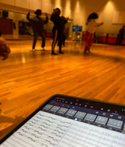 music score with dancers rehearsing