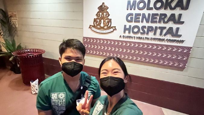 abad and xiao in front of  molokai hospital sign