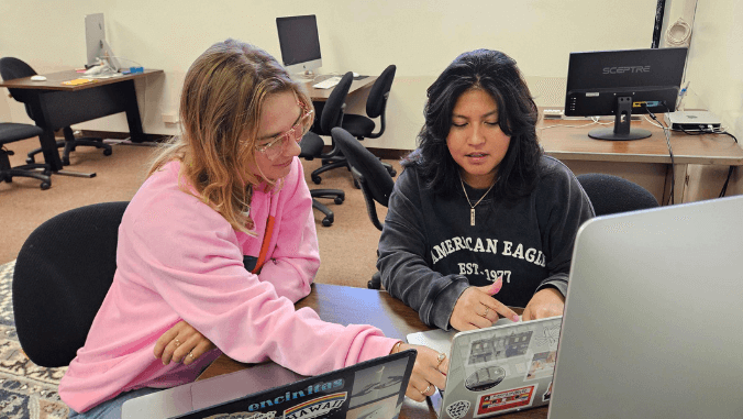 two girls working on laptops