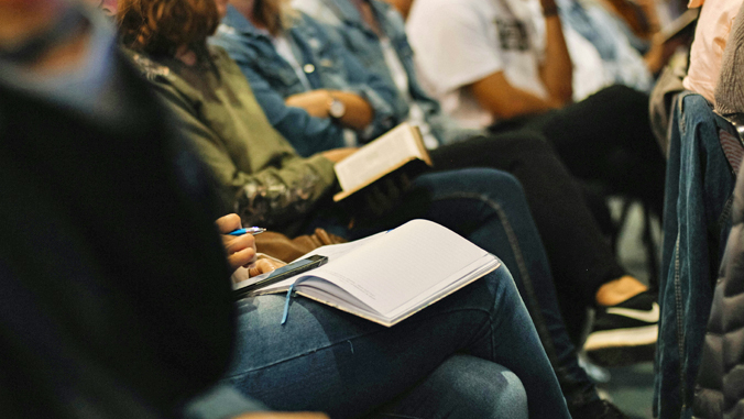 people sitting with notebooks