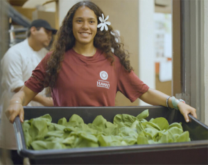 Krueger holding a bin of produce