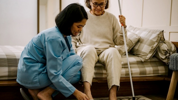 nurse helping elderly woman