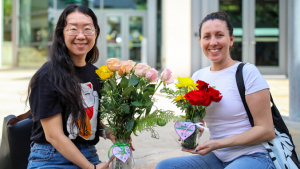 2 women holding flowers arrangements