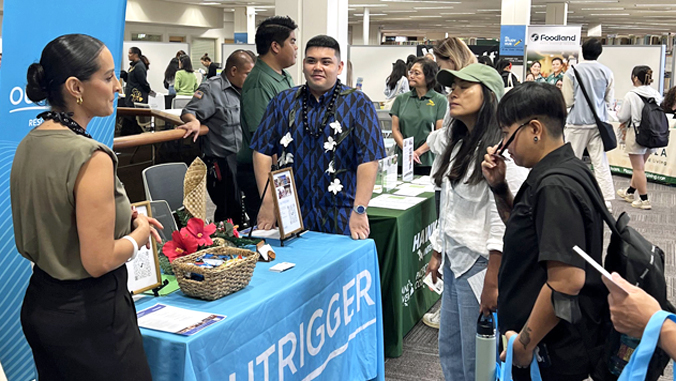 students talking to people at career fair booth