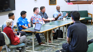 people sitting behind table talking to audience