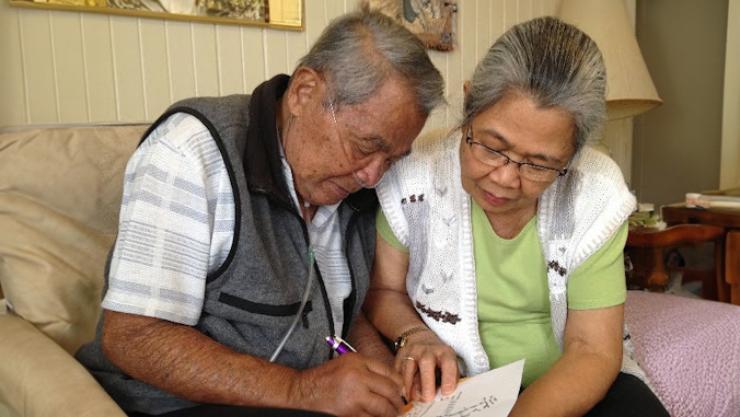 elder couple signing papers