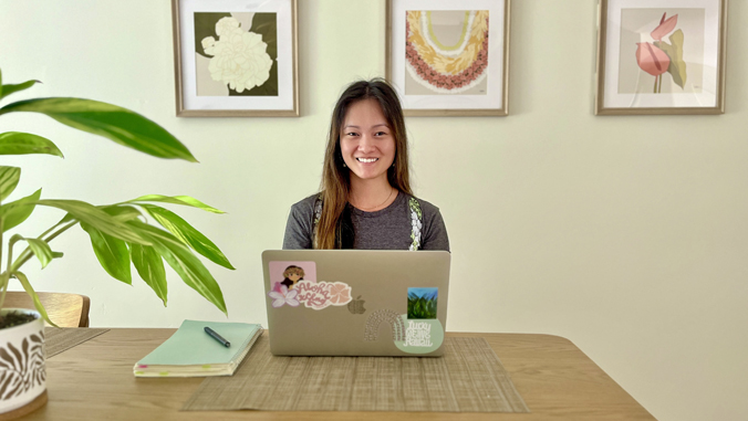 person sitting at a desk with a laptop and book